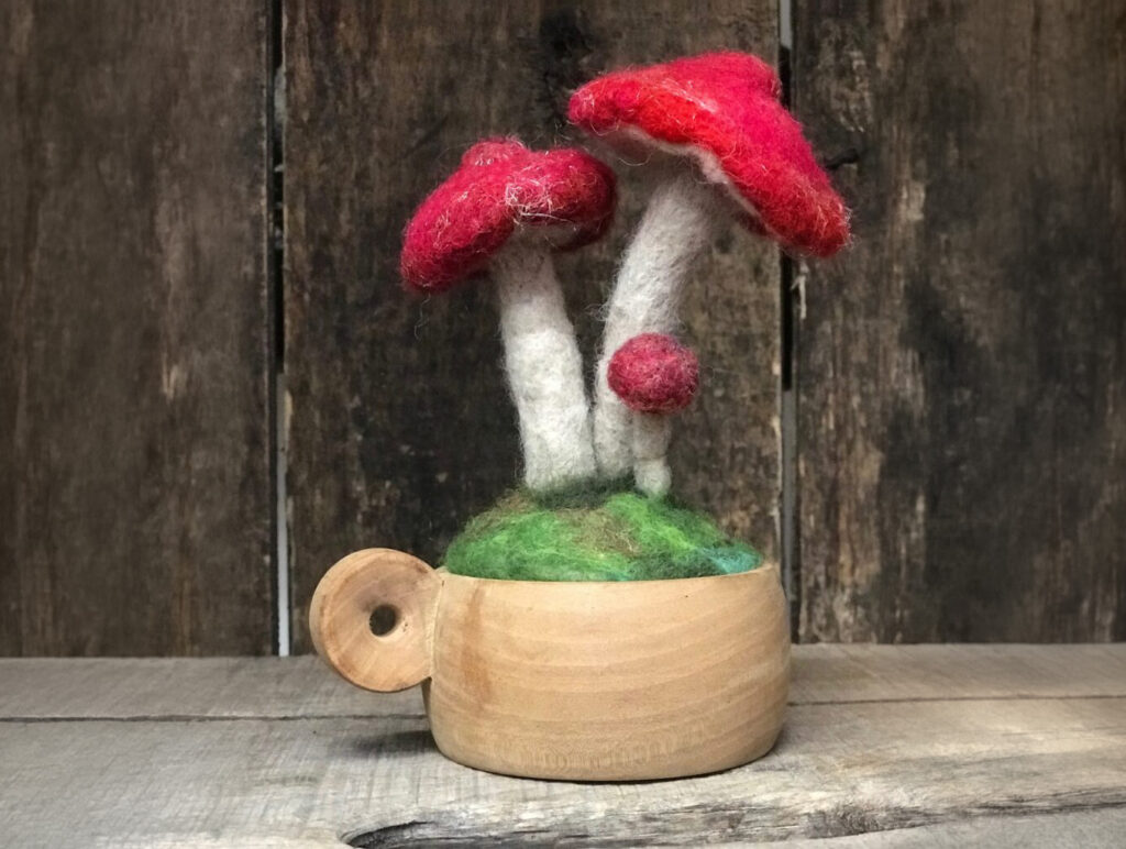 felted mushroom in a wooden cup